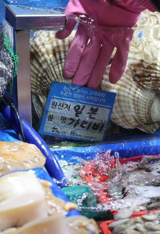 A merchant at Noryangjin Fish Market in western Seoul put scallops from Japan on display on Sunday. Korea’s import value of Japanese seafood shrank by 12.8 percent last year, the biggest decrease since 2012, a year after the Fukushima nuclear accident. [YONHAP]