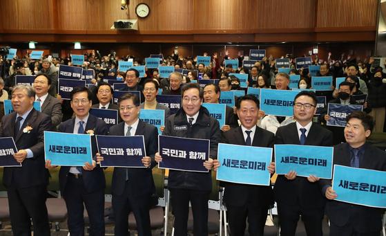 Former Democratic Party (DP) leader Lee Nak-yon, center, Park Won-seok, third from left, a former minor progressive Justice Party lawmaker, and other politicians take a commemorative photo at an event in Suwon, Gyeonggi, Sunday after announcing a merger between their splinter parties to form the “Future Reform Party” earlier that day. [NEWS1]