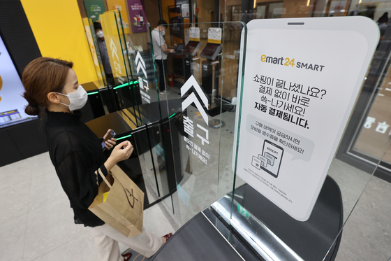 A shopper picks up items and walks out without paying at the checkout at Emart24 Smart Coex branch in southern Seoul. [YONHAP]