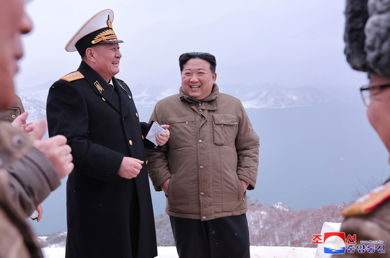 In this photo released by Pyongyang's state-controlled Korean Central News Agency on Monday, North Korean leader Kim Jong-un is seen laughing next to a naval official during a cruise missile test the previous day. [YONHAP]