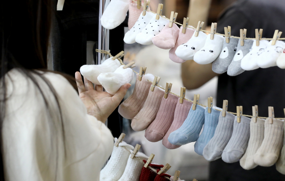 A customer takes a look at some infant socks at a baby products fair in Ilsan, Gyeonggi, on May 4. [NEWS1]
