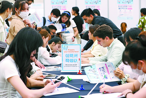 Attendees fill out their resume during the Job Fair for International Students held in Busan in July last year. [NEWS1]