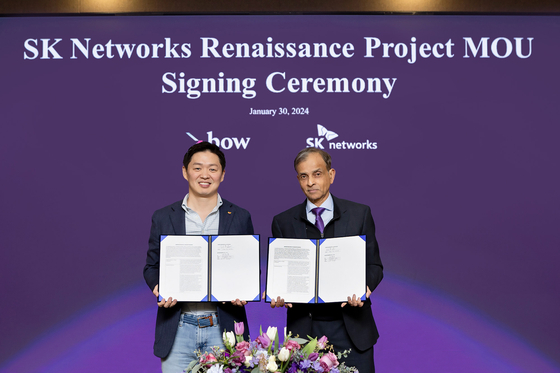 SK Networks President Choi Sung-hwan, left, and Vivek Ranadive, Managing Director of Bow Capital, pose after signing an agreement on Tuesday in Seoul. [SK NETWORKS] 