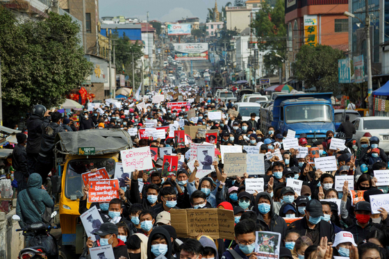 In this file photo, people take part in a demonstration against the Feb. 1 military coup, along a street in the town of Muse in Shan state, near the China-Myanmar border on Feb. 8, 2021. [AFP/YONHAP]