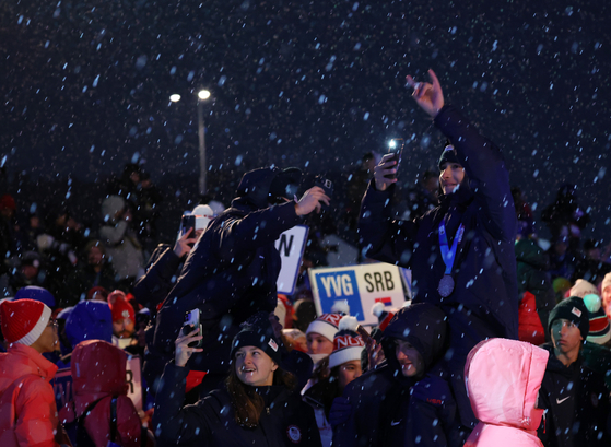The United States national team enjoys the closing ceremony of the Gangwon 2024 Winter Youth Olympics under the snow at Gangneung Olympic Park in Gangneung, Gangwon on Thursday. [YONHAP]