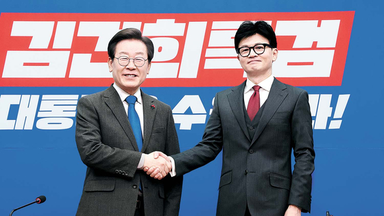 Han Dong-hoon, right, interim leader of the People Power Party, shakes hands with Democratic Party leader Lee Jae-myung at the National Assembly in Yeouido, western Seoul, on Dec. 29, 2023. [JOINT PRESS CORPS]