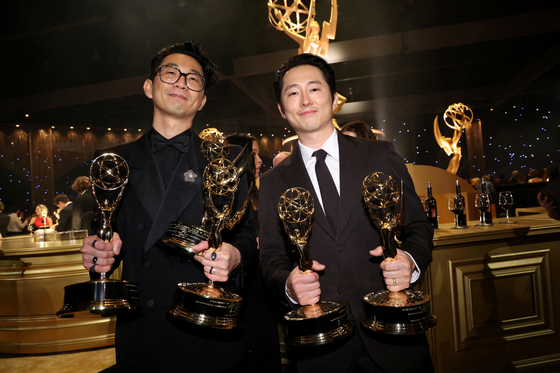 Director Lee Sung-jin, left, and actor Steven Yeun pose with their trophies for Netflix original series ″Beef″ at the 75th Emmy Awards Governors Gala Winners Circle held at the LA Convention Center in Los Angeles, California, on Jan. 15. [REUTERS/YONHAP]