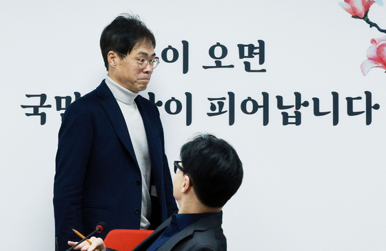 People Power Party (PPP) emergency steering committee member Kim Gyeong-ryul passes by the party interim leader Han Dong-hoon at the party's headquarters in Yeouido, Seoul, on Monday. [YONHAP]