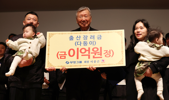 Booyoung Group Chairman Lee Joong-keun poses for a photo after presenting a childbirth incentive to a family with multiple births. Lee announced the initiation of a scheme offering 100 million won in cash per child to the 70 employees who have become parents since 2021 in response to the serious low birthrate issue. [YONHAP]