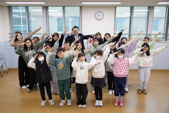 President Yoon Suk Yeol, center back, poses for a photo with students after observing a dance class, a part of the pilot Neulbom School after school care program, at Shinwoo Elementary School in Hanam, Gyeonggi on Monday. He later presided over the ninth public livelihood debate on education reform at the school. [JOINT PRESS CORPS]