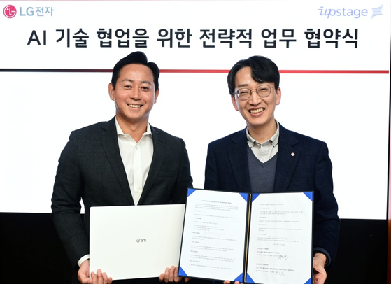 LG Electronics' Gong Hyuk-joon, head of Customer Experience strategy in the IT division, right, and Upstage Vice President Choi Hong-joon pose for a photo after a signing ceremony at LG Twin Tower in western Seoul. [LG ELECTRONICS]