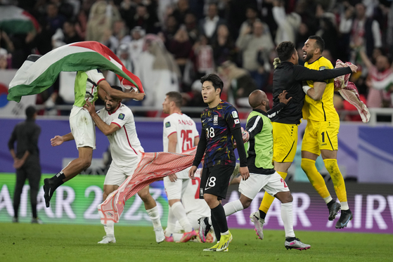 Korea's Lee Kang-in, center, reacts as Jordan players celebrates after winning the Asian Cup semifinal at Ahmad Bin Ali Stadium in Qatar on Tuesday.  [AP/YONHAP]