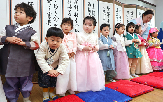 Children wearing hanbok, or traditional Korean clothes, learn how to do sebae, or the traditional deep bow to one's elders, ahead of the Lunar New Year, at the Incheon Hyanggyo Confucian School Yurim Hall in Michuhol District, Incheon, on Wednesday. [YONHAP] 