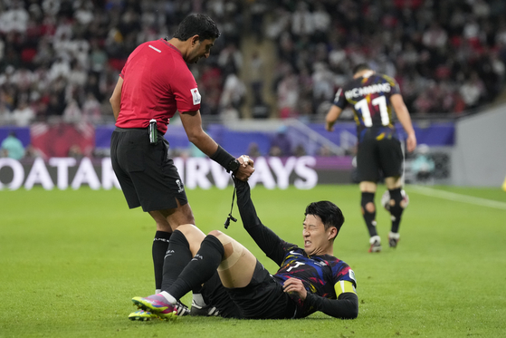 Korea's Son Heung-min is helped up by the referee. [AP/YONHAP]