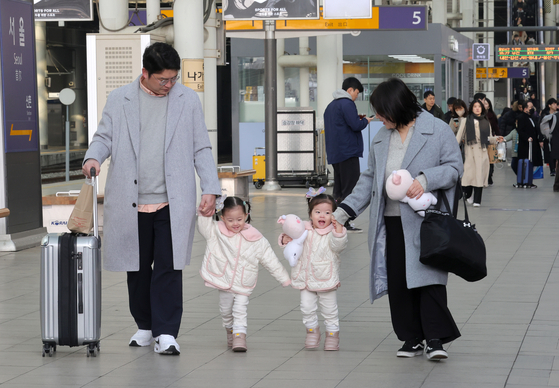 A family heads to a train bound for Busan from the platform of Seoul Station in downtown Seoul on Thursday, a day ahead of the four-day Lunar New Year holiday, also known as Seollal. [JANG JIN-YOUNG]