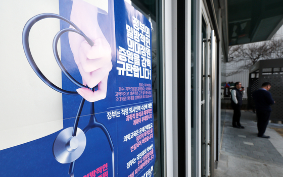 A poster opposing a hike in the medical school enrollment quota is spotted at the Korean Medical Association (KMA) headquarters in Yongsan District, central Seoul, on Tuesday, head of the KMA’s rallies set to be held nationwide Thursday. Trainee doctors have also been mulling collective action but did not come up with a statement after their overnight meeting on Monday. [NEWS1]