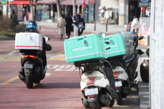 Motorcycles for food delivery services are parked on the road in Mapo District, western Seoul on Feb. 13. [YONHAP] 