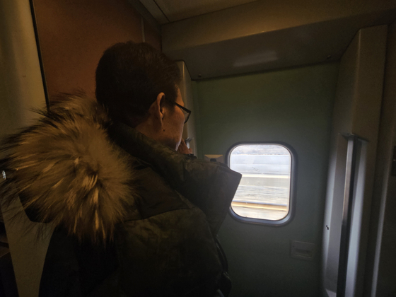 Kwon Sang-geun looks out the window of a train headed to Dongdaegu Station. In his 70s, he had to stand for an hour and 40 minutes until he arrived at his destination as he was unable to secure a seat online. [LEE YOUNG KEUN]