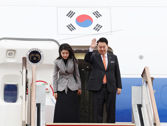 President Yoon Suk Yeol, right, waves alongside first lady Kim Keon Hee at Seoul Air Base in Seongnam, Gyeonggi, before departing on a trip to the Netherlands on Dec. 11, 2023. [JOINT PRESS CORPS]