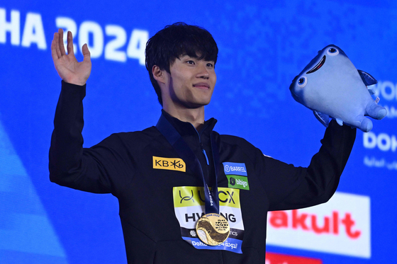 Gold medalist Hwang Sun-woo poses on the podium of the men's 200-meter freestyle during the 2024 World Aquatics Championships at Aspire Dome in Doha on Tuesday.  [AFP/YONHAP]
