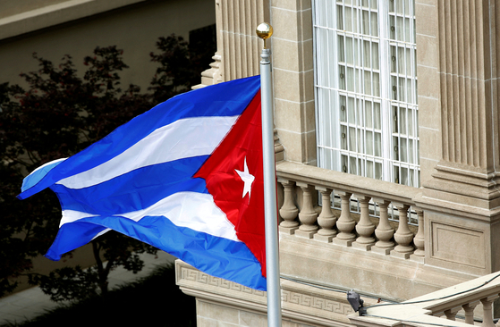 The Cuban flag flutters in the wind after being raised at the Cuban Embassy reopening ceremony in Washington in this file photo dated July 20, 2015. [REUTERS/YONHAP]