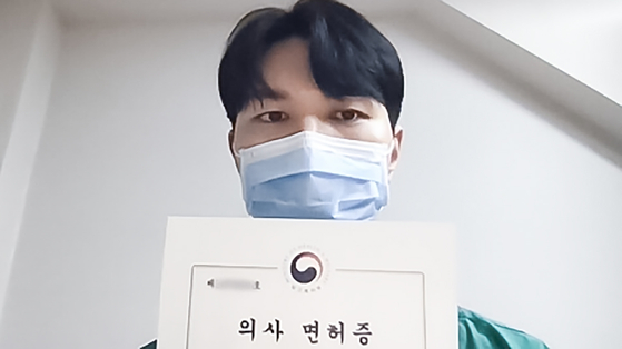 Intern Hong Jae-woo of Daejeon St. Mary's Hospital shows his medical license in a video he uploaded on YouTube announcing his decision to resign on Tuesday. [SCREEN CAPTURE] 