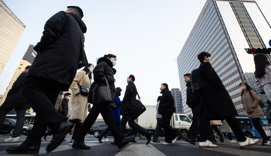 People walk toward their offices in central Seoul on Tuesday, a day after the Lunar New Year holiday. [NEWS1]