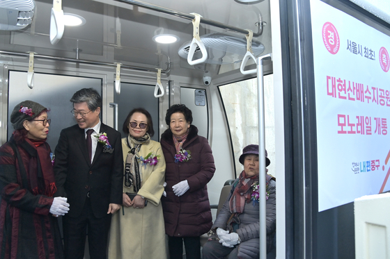 Kim Gil-sung, head of Jung District, rides the monorail with neighborhood's residents on Thursday in Seoul. [JUNG DISTRICT]
