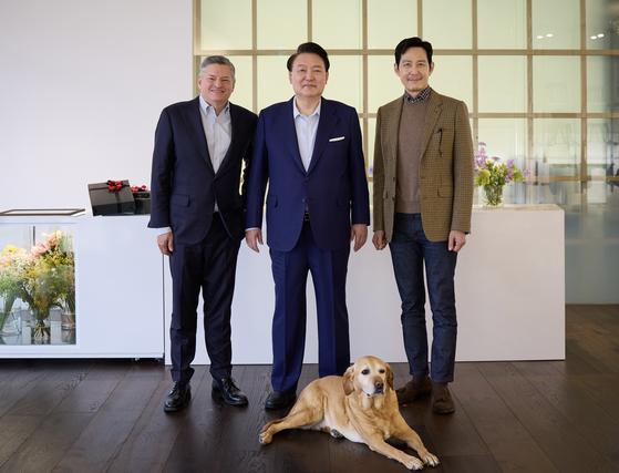 President Yoon Suk Yeol, center, Netflix co-CEO Ted Sarandos and ″Squid Game″ (2021) actor Lee Jung-jae pose for photos during a luncheon at the presidential office in Yongsan District, central Seoul on Saturday. [PRESIDENTIAL OFFICE]