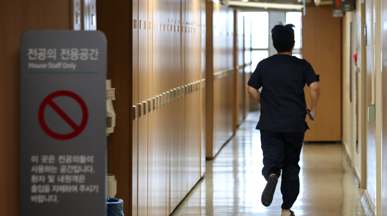 A trainee doctor runs through a hospital in Seoul on Sunday. Prime Minister Han Duck-soo on the same day urged doctors to refrain from going on strike amid their anticipated collective action as the government announced a medical school enrollment quota hike earlier this month. [NEWS1] 