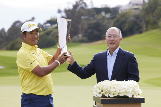 Hyundai Motor Group Executive Chair Euisun Chung, right, delivers a trophy to Japanese star Hideki Matsuyama, the winner of the 2024 Genesis Invitational at the Riviera Country Club in Los Angeles on Sunday. [HYUNDAI MOTOR]