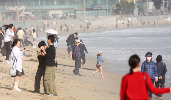 People flock to Haeundae Beach in Busan to enjoy the spring-like weather on Monday afternoon, when the mercury hit 24 degrees Celsius (75.2 degrees Fahrenheit), marking the fourth highest temperature ever recorded in February in the city. [YONHAP]