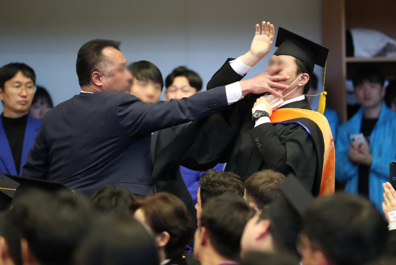 Shin Min-ki, spokesperson for the Daejeon wing of the Justice Party, is approached by security after he shouted at President Yoon Suk Yeol demanding a budget increase in the government’s research and development (R&D) field on Friday during the 2024 commencement ceremony held at the Korea Advanced Institute of Science and Technology. [NEW1]