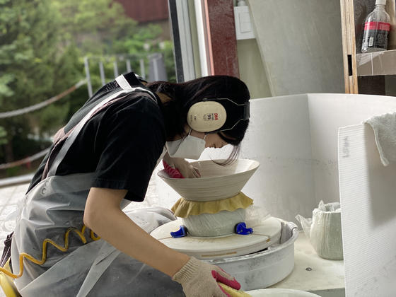 Yu Se-ri works on her Jupiter-inspired ceramics in her studio. [YU SE-RI]