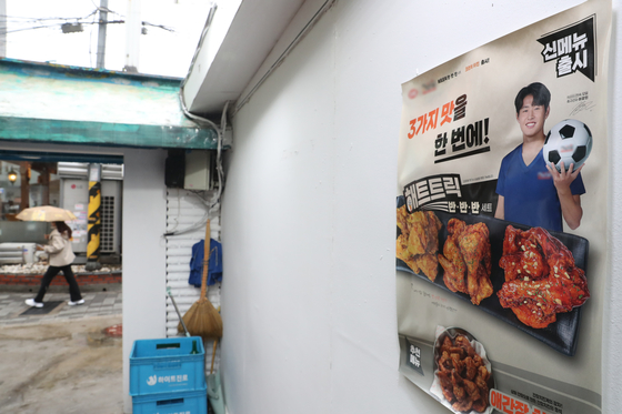 A promotional poster featuring Lee Kang-in for chicken franchise Alachi on a wall in Seoul. [NEWS1] 