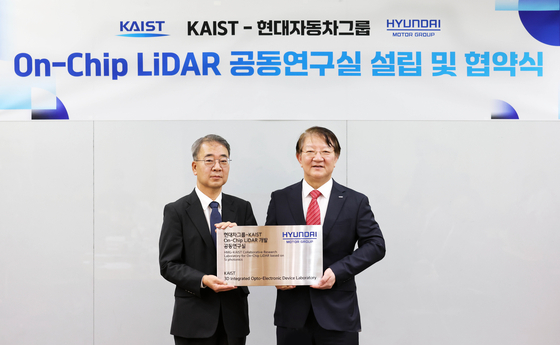 Lee Jong-soo, left, vice president of the institute of advanced technology at Hyundai Motor, and Lee Sang-yup, vice president at KAIST, take a photo after opening a lab at the university in Daejeon. [HYUNDAI MOTOR] 