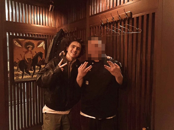 Actor Timothee Chalamet poses for photos with the owner of a restaurant in Seoul [SCREEN CAPTURE]