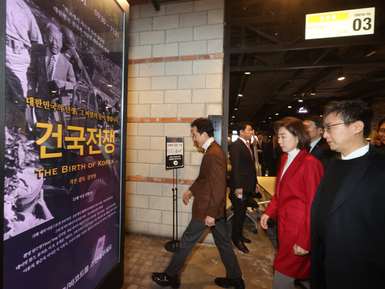 Former Minister of Patriots & Veterans Affairs Park Min-shik, left, former People Power Party lawmaker Na Kyung-won, and "The Birth of Korea" director Kim Deog-young, right, walk into the theater for a screening event held in western Seoul on Friday. [YONHAP]