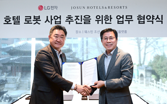 Josun Hotels & Resorts' CEO Lee Ju-hee, left, and LG Electronics' President of Business Solutions Jang Ik-hwan signed an MOU to develop hospitality robots, at the Westin Josun Hotel Seoul in Jung District, central Seoul, on Wednesday. [JOSUN HOTELS & RESORTS]