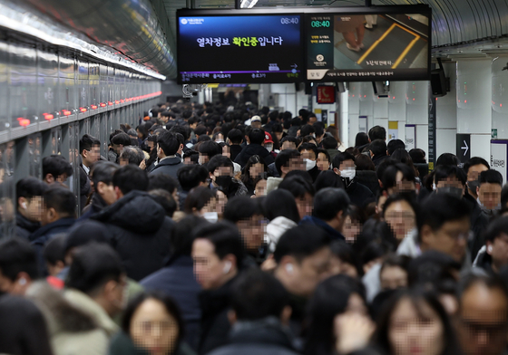 Passengers crowd the platform of Gwanghwamun Station, line No. 5, in central Seoul on Thursday morning. The line suffered delays during morning rush hour because of heavy snowfall. The information display reads that real-time operational status cannot be shared. [YONHAP]