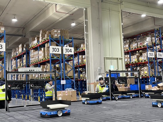 Mini automatic guided vehicles transport products and sort them according to their respective delivery destinations. [CJ LOGISTICS]