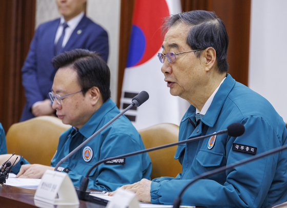 Prime Minister Han Duck-soo, right, on Friday speaks during the Central Disaster and Safety Countermeasures Headquarters' meeting held at the government complex in downtown Seoul. [YONHAP] 