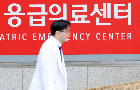 A doctor passes a medical center in downtown Seoul on Thursday. The Ministry of Health and Welfare said that a total of 9,275 trainee doctors across 100 major hospitals resigned as of 10 p.m. Wednesday. [NEWS1] 