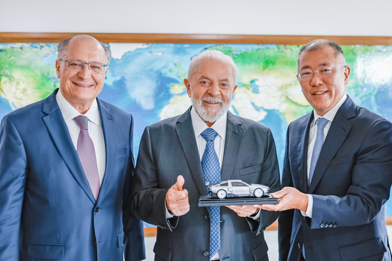 Brazil's President Luiz Inacio Lula da Silva, center, and Hyundai Motor Group Executive Chair, right, take a photo with a miniature of Hyundai's N Vision 74, a hydrogen-powered sports concept car, after a meeting on Feb. 22 in Brazil. [HYUNDAI MOTOR]