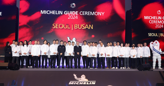 Chefs who received a star in the Michelin Guide Seoul and Busan 2024 pose for a photo after the list's unveiling ceremony at Busan Signiel on Thursday [MICHELIN GUIDE KOREA]