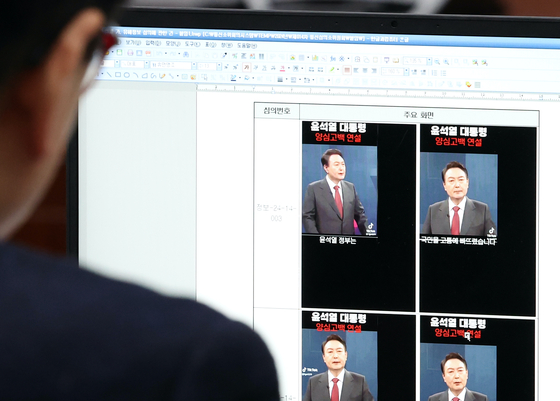 An official of the Korea Communications Standards Commission goes over material regarding a manipulated video of President Yoon Suk Yeol at a review meeting in western Seoul on Friday morning. [NEWS1] 
