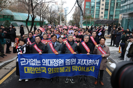 Doctors opposed to the government's proposed hike in medical school admissions arrive at the presidential office in Yongsan District, central Seoul, after marching from the nearby headquarters of the Korean Medical Association on Sunday. [NEWS1]