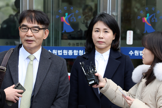 Kim Hye-hyung, right, leaves the Suwon District Court in Gyeonggi on Monday after the first trial hearing into the allegations against her. [YONHAP]