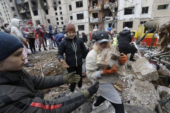 Ukrainians clear away rubble from a building destroyed by a Russian air strike in Kyiv on Jan. 3, 2024. [EPA/YONHAP]