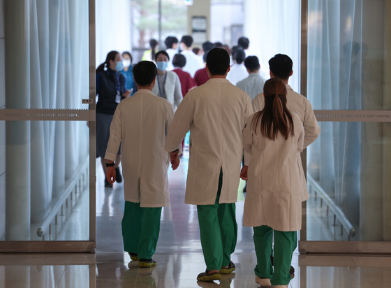 Medical professionals walk in the corridor of a hospital located in downtown Seoul on Thursday. [YONHAP] 